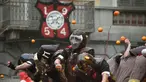 Sejumlah orang yang mengenakan helm melemparkan jeruk kepada warga sebagai bagian dari tradisi "perang jeruk" yang diselenggarakan selama Karnaval Ivrea di Turin, Italia (16/2). (AFP PHOTO/Olivier MORIN)