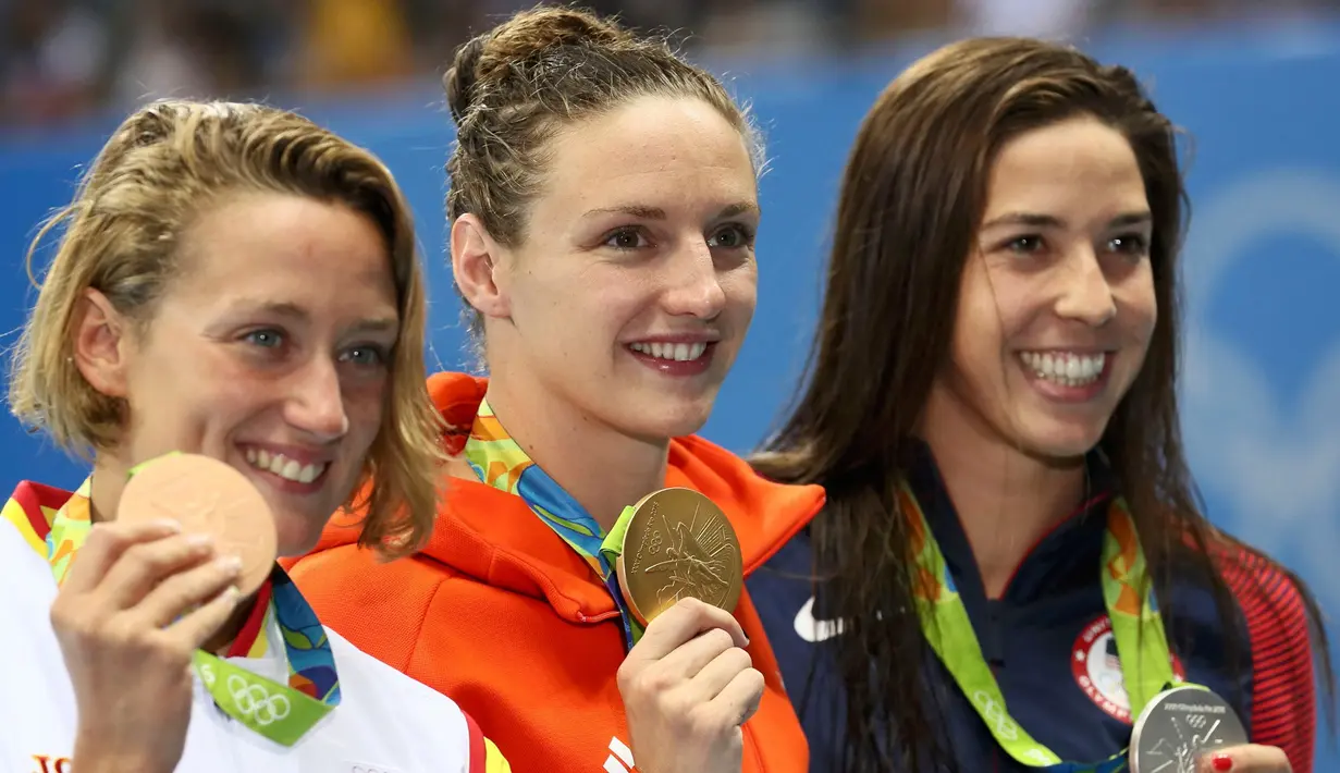 Atlet renang Hungaria, Katinka Hosszú (tengah)  mendapatkan mendali emas dalam 400m renang wanita Olimpiade 2016, Stadium Aquatics, Brasil, (6/8). Wanita dengan julukan 'Iron Lady' mendapat  mendali pertamanya dalam olimpiade. (REUTERS / Stefan Wermuth) 