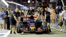 Mobil Toro Rosso Formula 1 yang dibawa Max Verstappen diperiksa saat sesi latihan F1 Grand Prix di Sirkuit Marina Bay, Singapura (17/9/2015). Kabut asap yang menyelimuti sirkuit tak menyurutkan pembalap untuk tetap melakukan pemanasan. (REUTERS/Tim Chong)