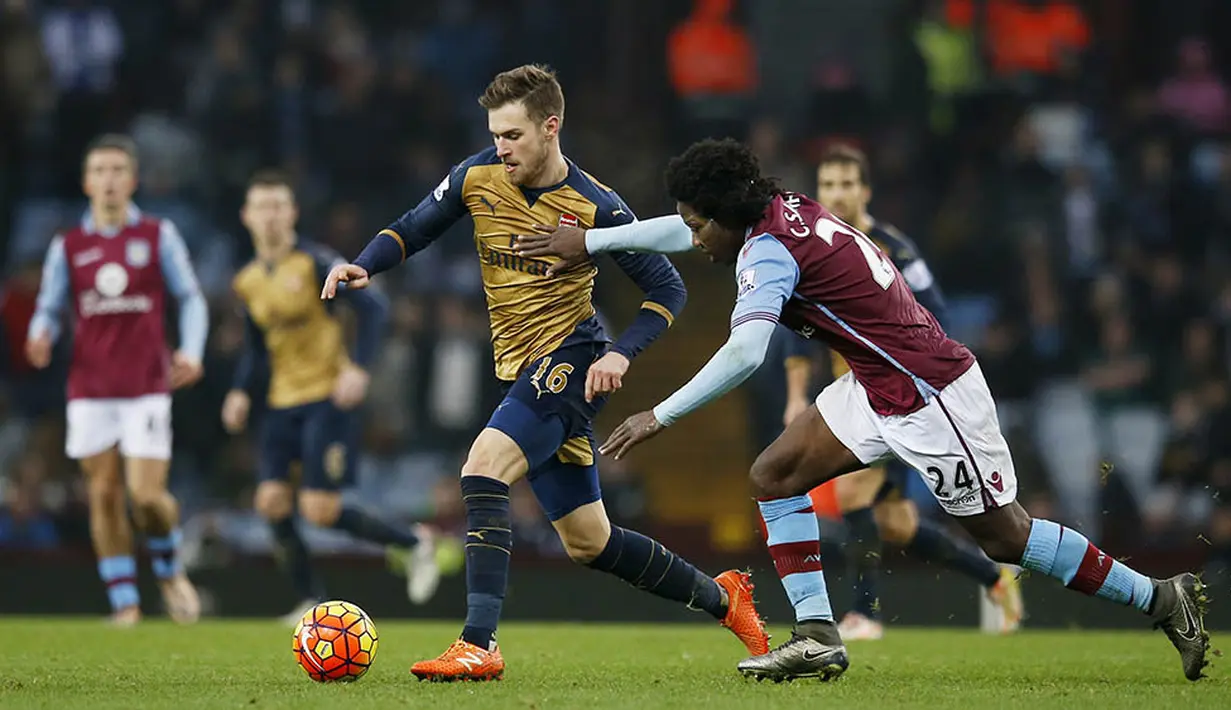 Gelandang Arsenal, Aaron Ramsey, berusaha melewati pemain Aston Villa, Carlos Sanchez, pada laga Liga Premier Inggris di Stadion Villa Park, Inggris, Minggu (13/12/2015). (Reuters/Paul Childs)