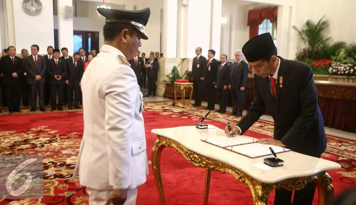 Presiden Joko Widodo menandatangani dokumen saat pelantikan Gubernur dan Wakil Gubernur hasil Pilkada serentak di Istana Negara, Jakarta, Jumat (12/2). (Liputan6.com/Faizal Fanani)