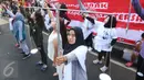 Relawan Kawan8 dan Mahasiswa IKJ membawa atribut timbangan yang melambangkan keadilan saat menggelar flashmob di Jalan Jenderal Sudirman, Jakarta, Minggu (5/3). (Liputan6.com/Helmi Afandi)