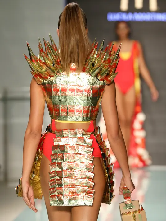 Model memperagakan busana koleksi yang diberi nama McDCouture Collection dalam Miami Swim Week di Florida, 20 Juni 2017. Koleksi baju renang tersebut dikreasikan dengan ribuan kemasan makanan cepat saji McDonald's. (ALEXANDER TAMARGO/GETTY IMAGES/AFP)