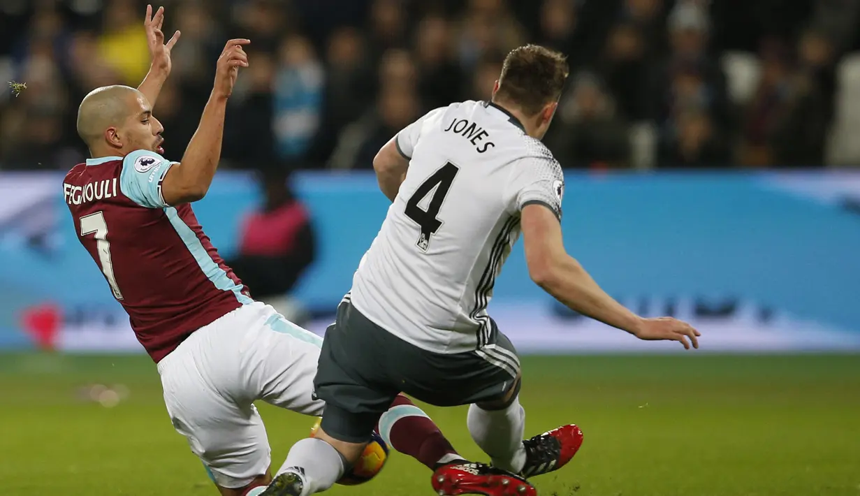 West Ham vs Manchester United. (2/1/2017). Gelandang West Ham, Sofiane Feghouli melakukan tekel terhadap bek Manchester United, Phil Jones yang berbuah kartu merah. Eks bek Manchester United, Gary Neville menilai reaksi Phil Noble berlebihan usai insiden tersebut. (AFP/Adrian Dennis)