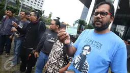 Koordinator KontraS,  Haris Azhar bersama sejumlah orang yang tergabung dalam Koalisi Masyarakat Sipil menunjukan KTP Elektronik saat melakukan aksi di depan Gedung KPK, Jakarta, Minggu (12/3). (Liputan6.com/Immanuel Antonius)