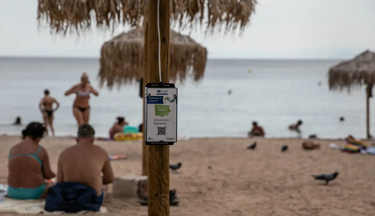 Pengisi daya bertenaga surya terpasang pada payung di pantai dekat Balai Kota Vari-Voula-Vouliagmeni, Yunani, Selasa (21/7/2020). Puluhan payung di pantai tersebut dilengkapi sistem panel surya dan port USB untuk menyediakan pengisian daya gratis dan ramah lingkungan. (Xinhua/Lefteris Partsalis)
