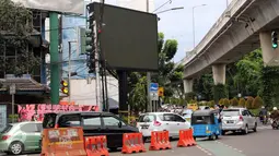 Kendaraan melintas di depan sebuah videotron di simpang Jalan Iskandarsyah, Jakarta Selatan, Minggu (2/10). Garis polisi terpasang terkait insiden videotron itu yang sempat memutar tayangan porno pada Jumat, 30 September 2016. (Liputan6.com/Helmi Afandi)