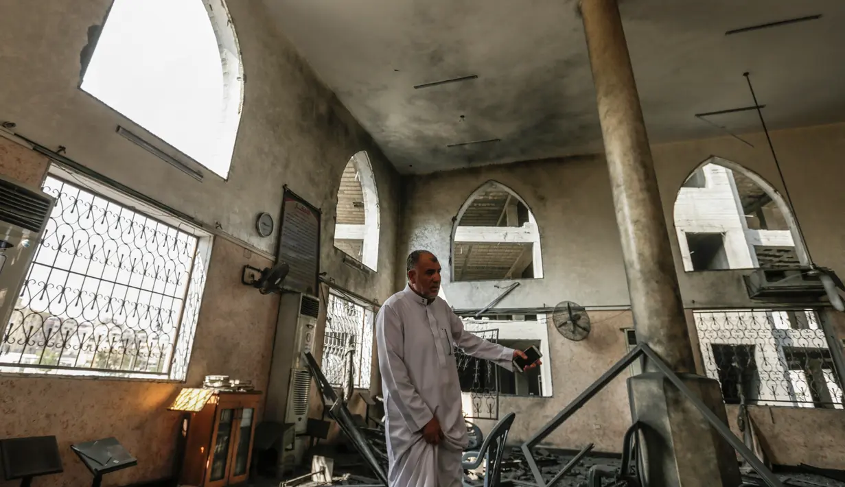 Seorang pria memeriksa kerusakan masjid yang terkena serangan udara Israel di Kota Gaza, Palestina (15/7). Serangan ini dilakukan untuk membalas Hamas yang melakukan peluncuran roket dan mortir ke wilayah selatan Israel. (AFP  Photo/Mahmud Hams)
