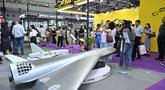 Pengunjung terlihat di samping model drone UAV Flying Eagle H3200 di stan Micro Multi Copter (MMC) selama Drone World Congress (DWC) di Shenzhen pada 21 Mei 2026. (HECTOR RETAMAL/AFP)