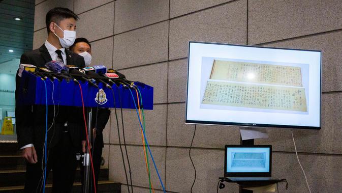 Polisi menunjukkan gambar gulungan kaligrafi karya Mao Zedong, yang telah ditemukan, pada konferensi pers di Hong Kong, 7 Oktober 2020. Gulungan sepanjang 2,8 meter itu ditemukan dalam keadaan terpotong menjadi dua bagian karena dianggap terlalu panjang untuk dipajang.    (ISAAC LAWRENCE/AFP)