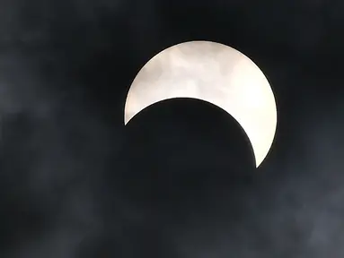 Seekor burung terbang saat gerhana matahari cincin di Bangkok, Thailand, Kamis (26/12/2019). Gerhana matahari cincin ini dapat diamati dari sejumlah wilayah mulai dari Afrika timur, seluruh Asia, Samudera India, dan Australia utara. (Lillian SUWANRUMPHA/AFP)