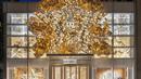 Menyalurkan kekuatan kreatif rumah ke etalase, tahun ini pohon cemara besar menutupi jendela depan butik Dior di New York dengan wujud ukiran emas. (Dok. Dior New York).