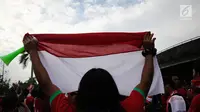 Seorang suporter membentangkan bendera Merah Putih jelang semifinal SEA Games 2017 di Stadion Sham Alam Selangor, Malaysia, Sabtu (26/8). Timnas Indonesia U-22 bakal berlaga melawan Malaysia. (Liputan6.com/Faizal Fanani)
