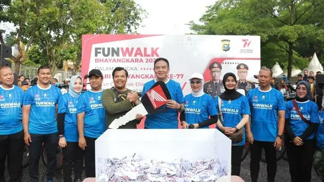 Kapolda Riau Irjen Mohammad Iqbal secara simbolis menyerahkan kunci sepeda motor kepada seorang peserta Fun Walk Bhayangkara yang beruntung.