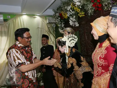 Cawagub DKI Jakarta Djarot Saiful Hidayat memberi ucapan selamat kepada pengantin di Petogogan I, Jakarta Selatan, Minggu (11/12). Djarot berpesan kepada warga untuk menjaga kebersihan dan lingkungan. (Liputan6.com/Fery Pradolo)