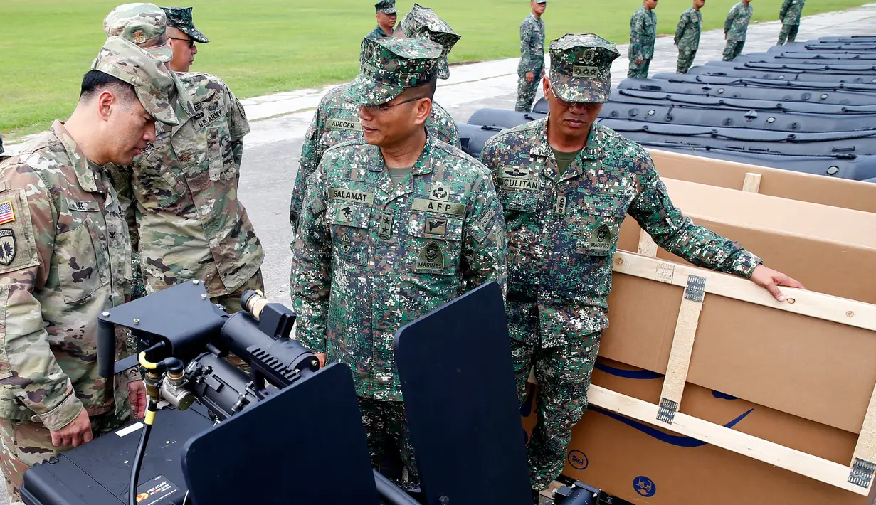Kolonel Ernest Lee didampingi Mayjen Emmanuel Salamat memeriksa senjata militer baru pemberian AS di kota Taguig, sebelah timur Manila, Filipina (5/6). Senjata itu akan digunakan untuk operasi militer melawan militan di Marawi. (AP Photo / Bullit Marquez)