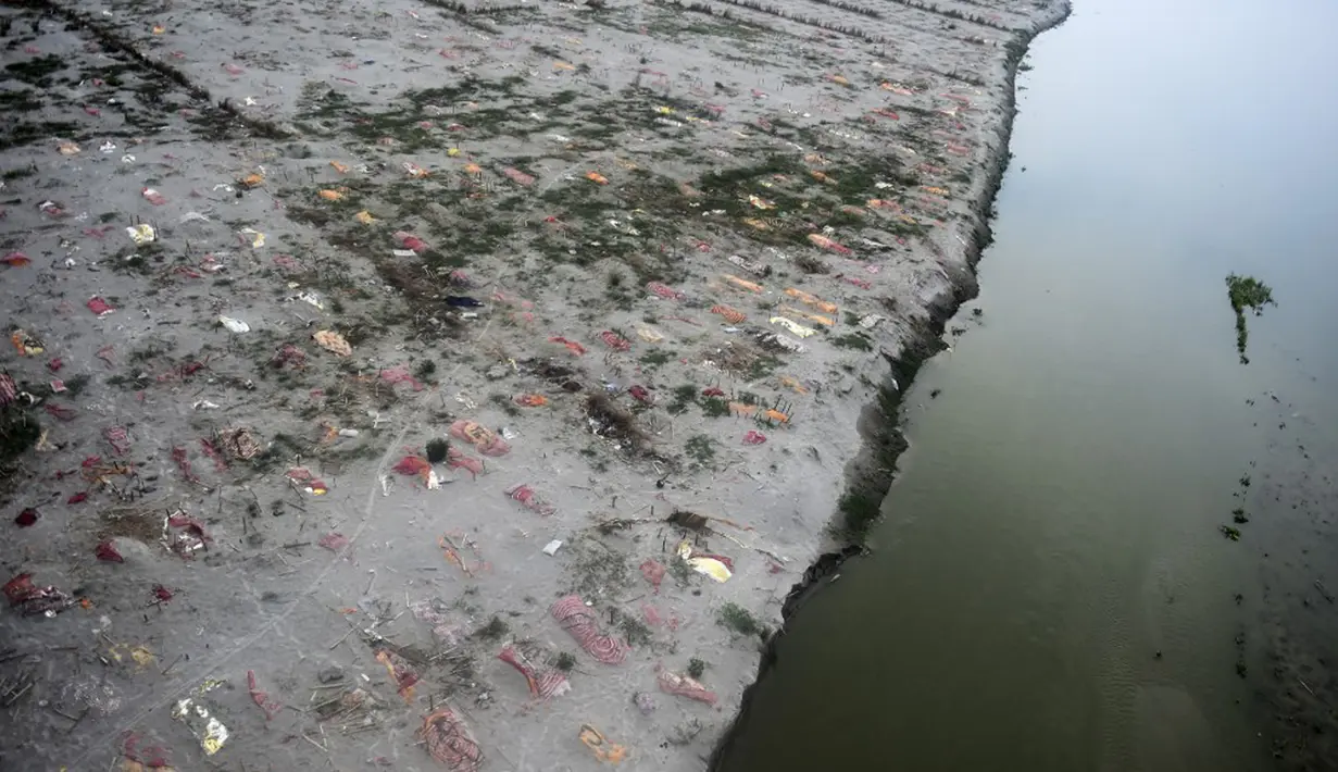 Kuburan dangkal di pasir, beberapa di antaranya diduga orang yang meninggal karena virus corona COVID-19, terlihat dekat tempat kremasi di tepi Sungai Gangga, Phafamau, Allahabad, India, Sabtu (5/6/2021). (SANJAY KANOJIA/AFP)