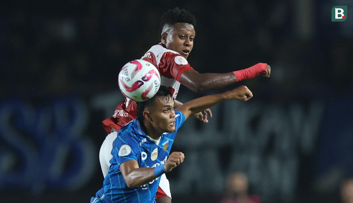 <p>Pemain Madura United, Hugo Gomes Do Santos Silva (Jaja) (atas)&nbsp;berduel udara&nbsp;dengan pemain Persib Bandung, Rachmat Irianto pada laga leg 1 final Championship Series BRI Liga 1 2023/2024 antara Persib Bandung melawan Madura United di Stadion Si Jalak Harupat, Bandung, Minggu (26/05/2024). (Bola.com/M Iqbal Ichsan)</p>