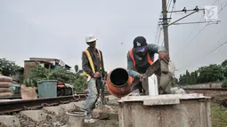 Pekerja menyelesaikan pondasi tiang sinyal elektrik jalur DDT Manggarai-Cikarang, Jakarta, Selasa (13/11). Pemasangan sistem persinyalan untuk Paket B1 DDT yang memiliki panjang lintasan 34 kilometer. (Merdeka.com/Iqbal S. Nugroho)