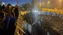Para pengunjuk rasa duduk di atas sebuah gedung di sebelah kedutaan Swedia di Bagdad pada 20 Juli 2023. (AFP/Ammar Karim)