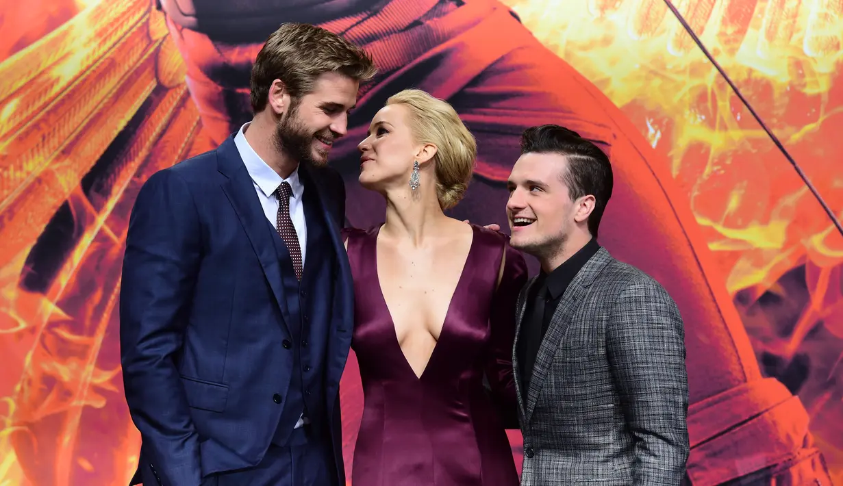 (Kiri-kanan) Aktor Liam Hemsworth, aktris Jennifer Lawrence dan aktor Josh Hutcherson berpose untuk fotografer saat menghadiri pemutaran perdana film "The Hunger Games : Mockingjay Part 2" di Berlin, Jerman, Rabu (4/11). (AFP PHOTO/JOHN MacDougall)