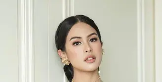 Penambahan kalung, anting, dan hiasan rambut emas menambah kesan glamor.