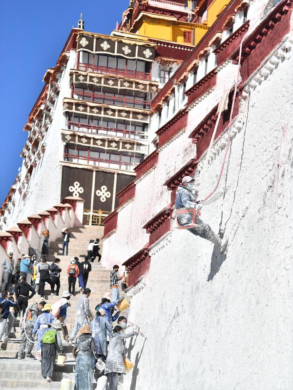 Para pekerja mengecat tembok Istana Potala dalam rangka renovasi tahunan kompleks arsitektur kuno tersebut di Lhasa, ibu kota Daerah Otonom Tibet, China barat daya, pada 28 Oktober 2020. (Xinhua/Jigme Dorji)