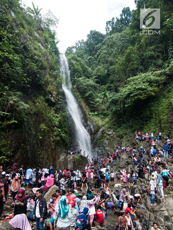 Sejumlah wisatawan menikmati air terjun di Kabupaten Karawang, Jabar, Kamis (29/6). Wisatawan memanfaatkan liburan Lebaran untuk mengunjungi tempat wisata bersama keluarga. (Liputan6.com/Gempur M Surya)
