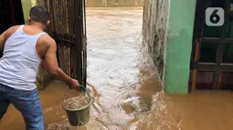 Warga beraktivitas di tengah banjir yang merendam kawasan Kebon Pala, Jakarta Timur, Selasa (25/2/2020). Akibat banjir yang tak kunjung surut, aktivitas warga di kawasan tersebut menjadi terganggu, terlebih dengan adanya pemadaman listrik. (Liputan6.com/Immanuel Antonius)