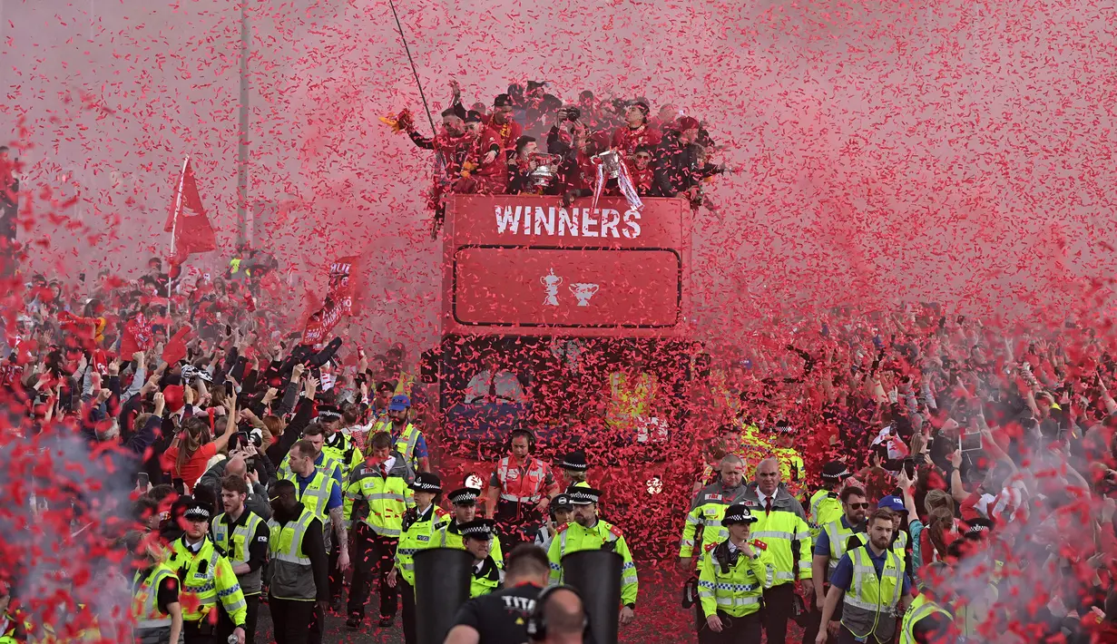 Ribuan fans Liverpool memadati jalan-jalan kota untuk menyambut tim kebanggaan mereka yang melakukan parade di atas bus terbuka pada Minggu (29/05/2022) waktu setempat. Musim ini, The Reds berhasil meraih dua trofi yaitu Piala FA dan Piala Liga Inggris. (AFP/Oli Scarff)