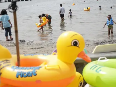 Sejumlah anak bermain air dikawasan pantai Ancol, Jakarta, Jumat (14/4). Walaupun tak seramai libur biasanya, pantai Ancol masih menjadi primadona masyakarat Jakarta maupun luar Jakarta menghabiskan libur bersama keluarga. (Liputan6.com/Faizal Fanani)