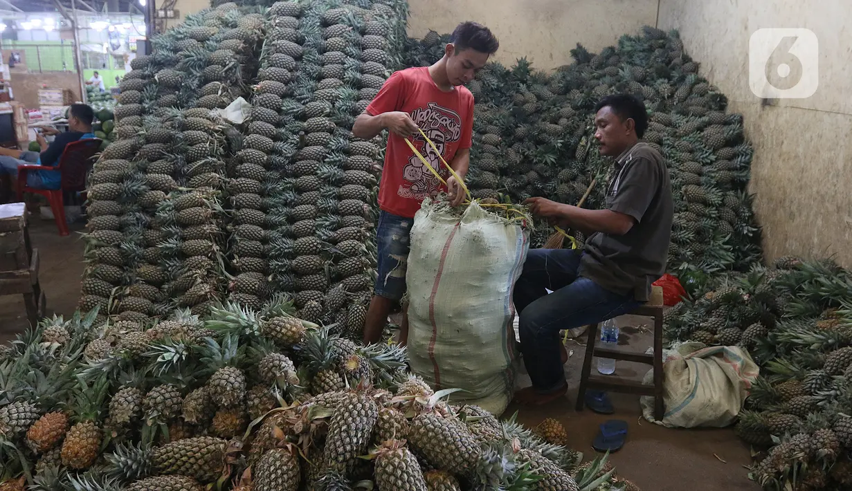 Pedagang memasukan buah nanas di pasar induk Kramat Jati, blok buah di Jakarta, Minggu (2/2/2020). Pemerintah berupaya melakukan peningkatan produksi buah-buahan dalam negeri dan diharapkan tidak hanya dilakukan untuk mendongkrak ekspor. (Liputan6.com/Herman Zakharia)
