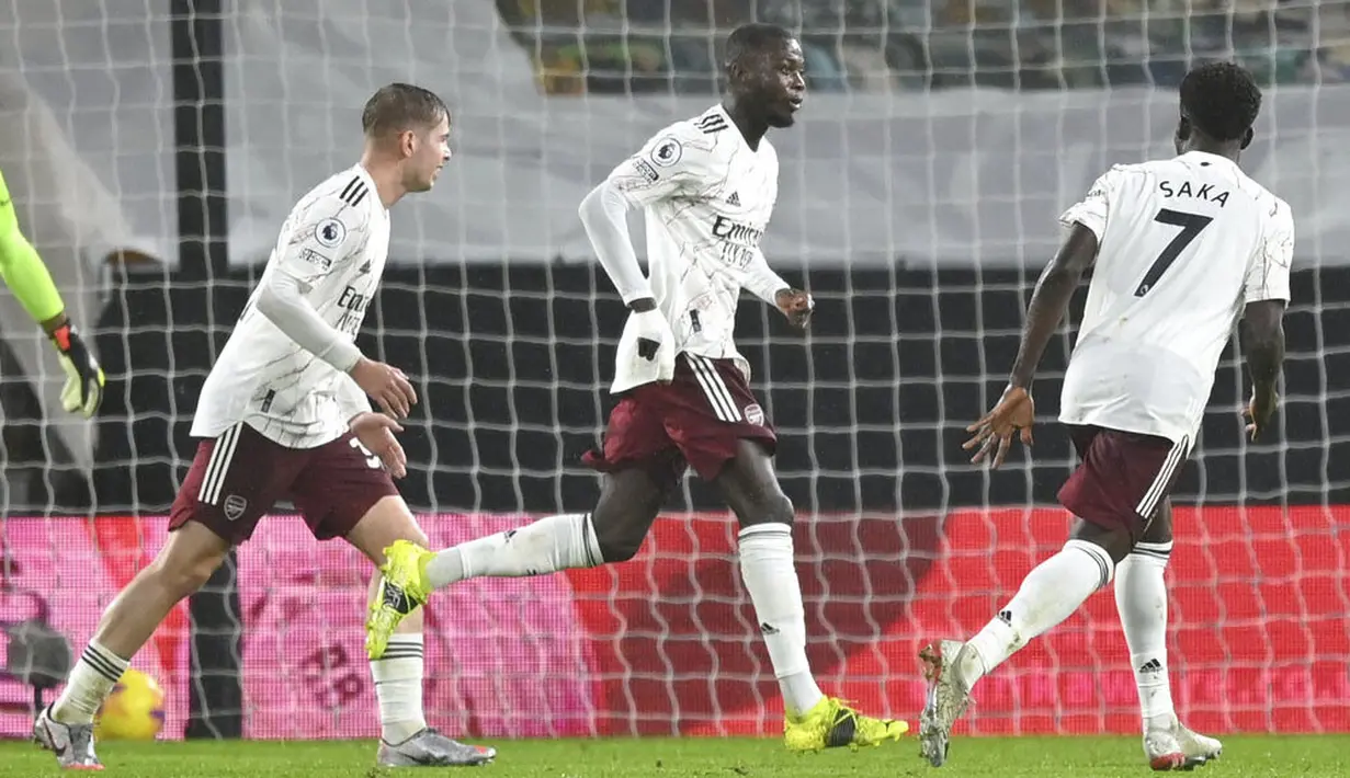 Striker Arsenal, Nicolas Pepe, melakukan selebrasi usai mencetak gol ke gawang Wolverhampton Wanderers pada laga Liga Inggris di Stadion Molineux, Selasa (2/2/2021). Arsenal takluk dengan skor 2-1. (Shaun Botterill/Pool via AP)