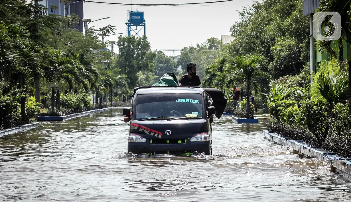 Kendaraan bermotor melintasi jalan yang tergenang air rob (banjir pasang air laut) di Kawasan Pasar Ikan Muara Baru, Jakarta, Kamis (4/6/2020). Banjir rob di Pelabuhan Muara Baru tersebut terjadi akibat cuaca ekstrem serta pasangnya air laut. (Liputan6.com/Faizal Fanani)