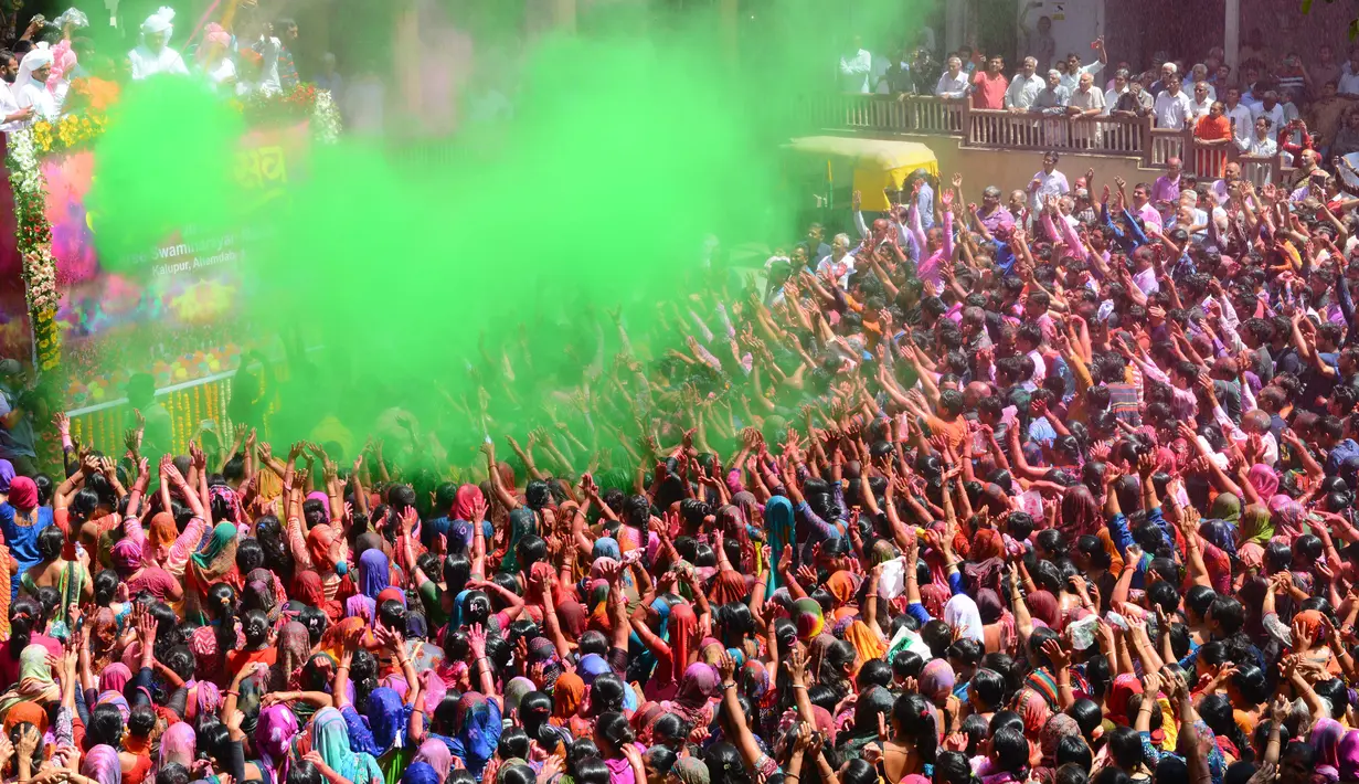 Umat Hindu India disemprot dengan cairan berwarna dalam festival Holi di Kuil Swupramayan Kalupur, Ahmedabad, Rabu (20/3). Holi juga menjadi libur nasional yang biasanya bertepatan dengan hari terakhir purnama dalam kalender Hindu. (SAM PANTHAKY / AFP)