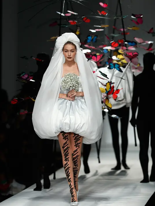 Gigi Hadid berjalan di runway mengenakan gaun rumah mode Moschino untuk koleksi SS19 selama gelaran fashion week di Milan, Italia, Kamis (20/9). Gigi tampil dalam balutan gaun pengantin berpotongan pendek dengan desain menggelembung. (AP/Antonio Calanni)