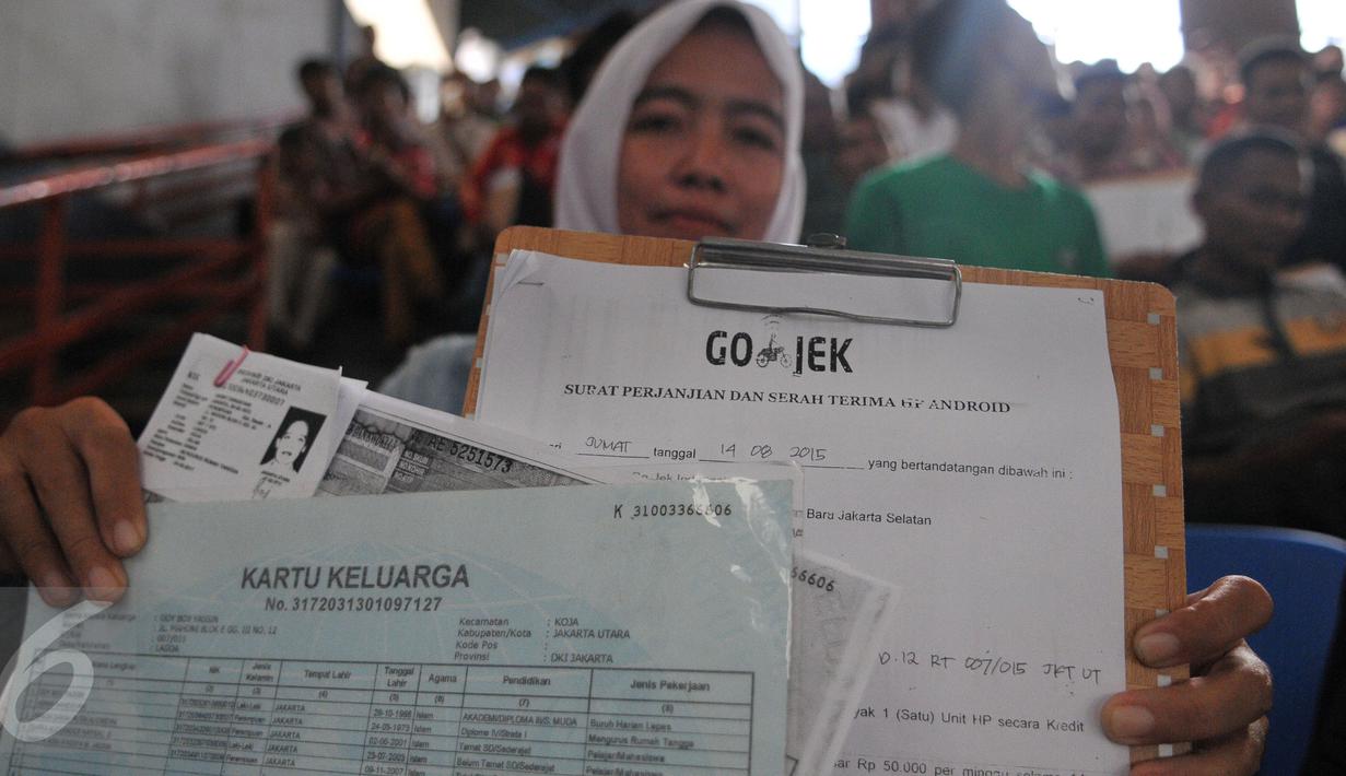 Seorang wanita memperlihatkan dokumen persyaratannya untuk mendaftar sebagai pengendara Go-Jek  di Hall A Basket Senayan, Jakarta, Jumat (14/8/15). Fenomena ojek online dengan aplikasi di hanphone kini banyak diminati. (Liputan6.com/Herman Zakharia)