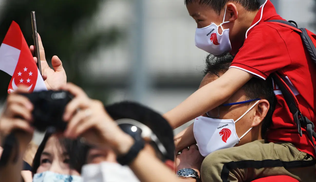 Masyarakat menyaksikan atraksi pesawat dalam perayaan Hari Kemerdekaan di Merlion Park, Singapura, Minggu (9/8/2020). Singapura pada 9 Agustus 2020 memperingati 55 tahun kemerdekaannya. (Xinhua/Then Chih Wey)