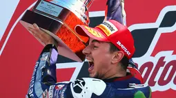 Jorge Lorenzo mengangkat piala usai sukses menjadi juara dunia MotoGP 2015 di seri terakhir Grand Prix Valencia Spanyol, Minggu (8/11). Lorenzo berhasil finis terdepan, disusul Marc Marquez dan Dani Pedrosa. (REUTERS/Heino Kalis)