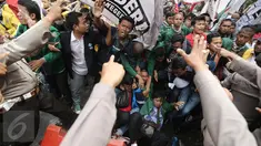 Sejumlah mahasiswa dari BEM Se-Jabodetabek terjatuh saat menggelar aksi unjuk rasa di depan Istana Negara, Kamis (12/1). Dalam aksinya mereka menuntut Presiden Jokowi-JK untuk membuat kebijakan yang pro terhadap rakyat. (Liputan6.com/Faizal Fanani)