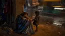 Seorang perempuan tunawisma duduk di dekat pintu masuk ke tempat penampungan bobrok untuk para tunawisma di New Delhi, 30 Desember 2022. Dingin yang menusuk adalah cobaan berat bagi para tunawisma kota, dengan New Delhi Sunday mencatat suhu minimum 5,5 derajat Celcius (41,9 Fahrenheit). (AP Photo/Altaf Qadri)