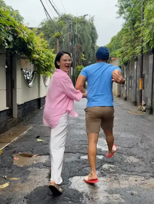 Kemeja pink tersebut dipadukan celana putih panjang. Sementara Anjasmara mengenakan celana pendek coklat dan sandalnya. [@anjasmara]
