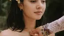 Setelah tubuhnya disiram air dari atas oleh pemuka upacara, Aurelie tampak mengenakan kembang kamboja berwarna kuning yang cantik, yang diselipkannya di salah satu telinganya. Foto: Instagram.