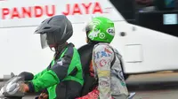 Pengendara ojek online bersama penumpang melintas di kawasan Terminal Kalideres, Jakarta, Selasa (22/3). Dengan adanya aksi demo angkutan umum di ruas Jakarta penumpang terlantar di sejumlah terminal. (Liputan6.com/Faisal R Syam)