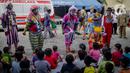 Anak-anak menyaksikan aksi badut yang tergabung dalam komunitas Aku Badut Indonesia (ABI) di pengungsian korban banjir di Gor Pangadegan, Jakarta, Selasa (7/1/2020). Trauma healing diberikan para badut sebagai bentuk kepedulian terhadap anak-anak korban banjir Jakarta. (Liputan6.com/Faizal Fanani)