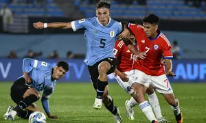 Gelandang Chile Marcelino Nunez, kanan, berbeut bola dengan gelandang Uruguay Manuel Ugarte  dalam Kualifikasi Piala Dunia 2026 zona CONMEBOL di Estadio Centenario, Sabtu (9/9/2023) pagi WIB. (AP Photo/Santiago Mazzarovich)