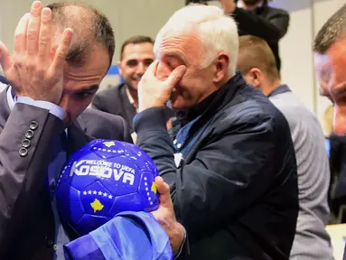 Delegasi sepak bola Kosovo menangis bahagia saat merayakan diterimnya Kosovo sebagai anggota UEFA pada kongres UEFA ke-40 tahun di Hungexpo Fair Center, Budapest, Hungaria, (3/52016). (AFP/Attila Kisbenedek)