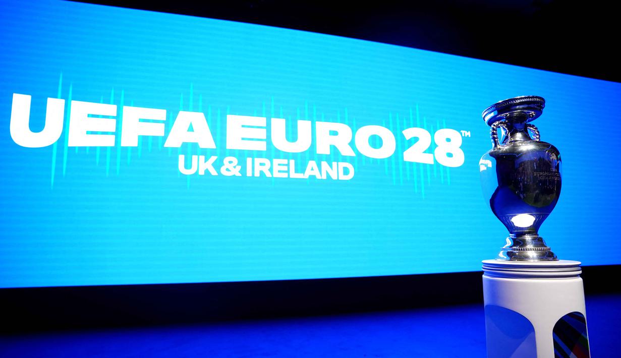 Turnamen ini akan menampilkan 51 pertandingan dengan 24 negara peserta di sembilan stadion yang tersebar di delapan kota. Kota-kota tersebut antara lain Birmingham, Dublin, Glasgow, Liverpool, Manchester, dan Newcastle. Tampak dalam foto, trofi EURO atau Piala Henri Delaunay ditampilkan sebelum acara peluncuran turnamen sepak bola UEFA EURO 2028 di Below The Lights, London Pusat, pada 12 November 2025. (James Manning/POOL/AFP)