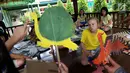 Siswa sedang mendengar penjelasan dari pelukis wayang sebelum mewarnai wayang kulit di Jakarta Intercultural School (JIS) Elementary, Jakarta, Kamis (2/11). Kegiatan ini merupakan bagian dari JIS cultural week. (Liputan6.com/Fery Pradolo)