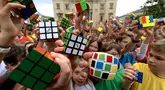 Murid-murid Hungaria berpose dengan Kubus Rubik usai melakukan flashmob di Budapest pada 12 Juni 2024. (Ferenc ISZA/AFP)